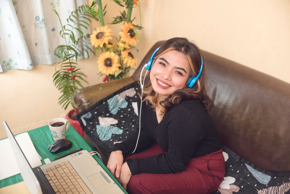 A freelance transcription agent smiling for a shot during her online meeting with her team for an event.
