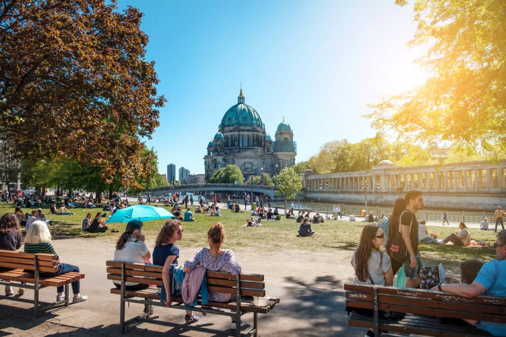 Berlin, Germany - April, 2019: People in public park on a sunny day near Museum Island and Berlin Cathedral
