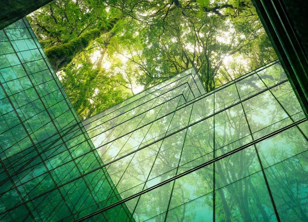 Eco-friendly building in the modern city. Sustainable glass office building with tree for reducing heat and carbon dioxide. Office building with green environment. Corporate building reduce CO2. 