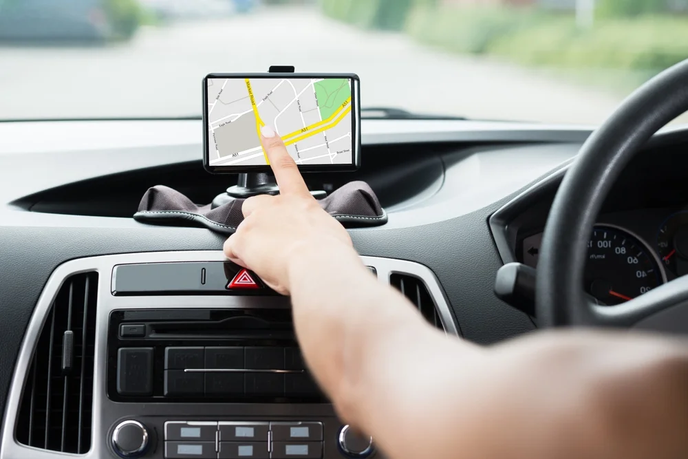 Close-up Of Female's Hand Using GPS Navigation Inside Car
