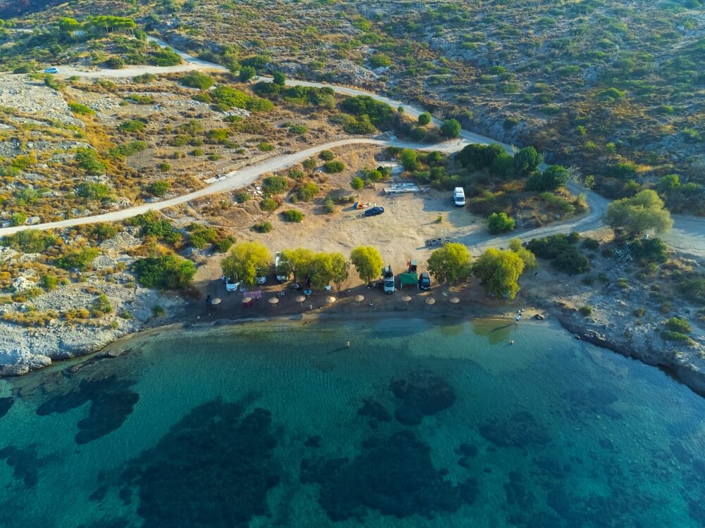 Drone view RVs in motorhome parking lot near beach on coastline. Family caravan on wheels by sea. Lifestyle Journey to Sea. Campervan along coast of Turkey. Caravanning parking lot. Campsite.
