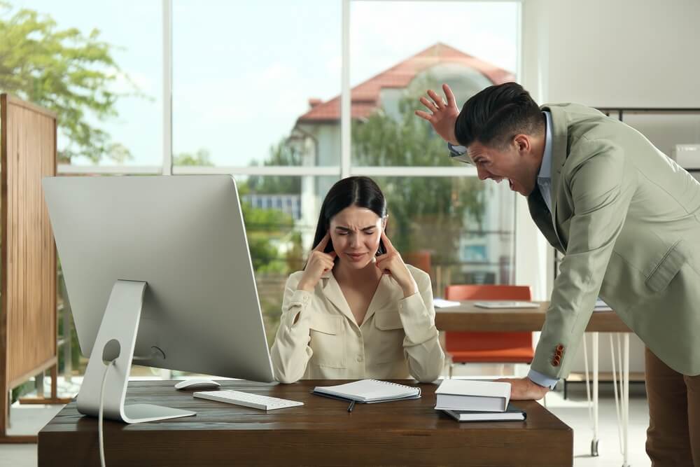 Boss screaming at employee in office. racism in the work environment
