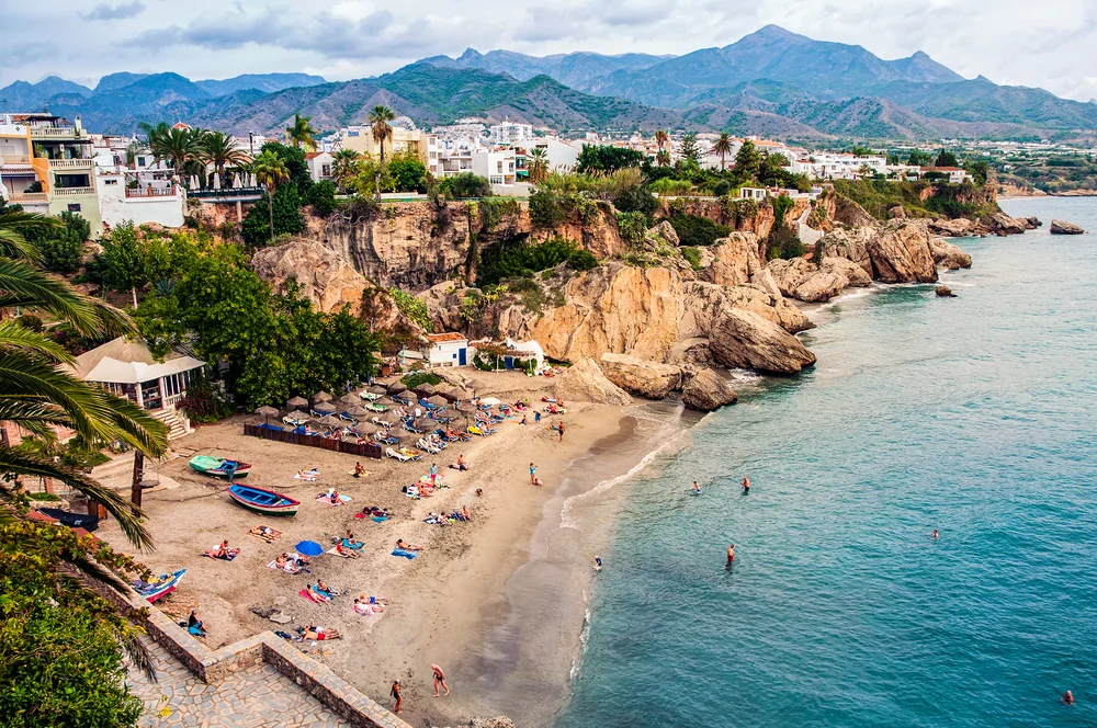 Little touristic town Nerja in Costa del Sol, Andalusia, Spain. It has many restaurants, bars and cafes. Aerial view of the beach
