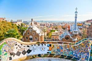 Colorful mosaic terrace in Park Güell overlooking Barcelona skyline in spring – one of the best times of the year to visit Spain for art and culture lovers