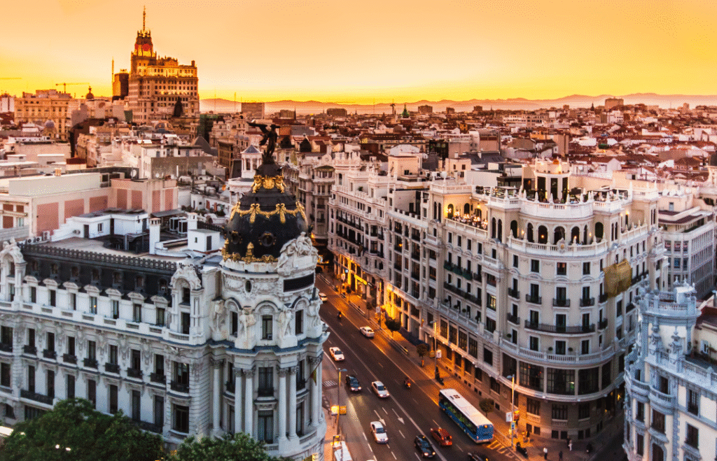 Sunset over Madrid's Gran Vía with classic architecture and city lights – perfect destination for exploring Spain in autumn or winter
