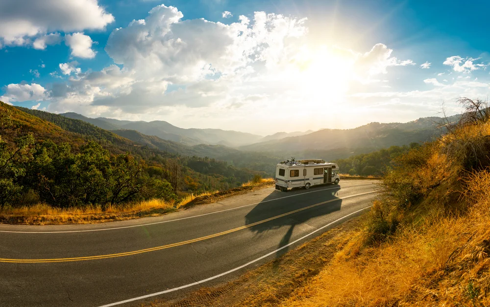 Epic nature mountain view with a road side parked RV motorhome. Travelling lifestyle roadtrip adventure in the USA