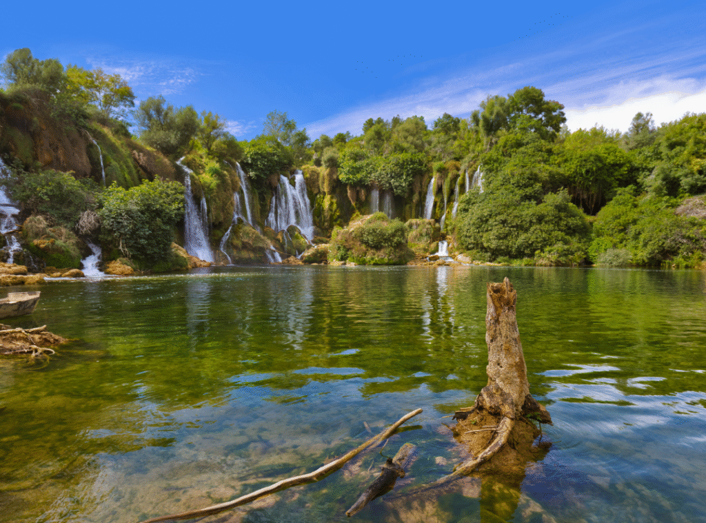 Kravice Waterfalls in Bosnia and Herzegovina with clear green water and lush forest, a popular natural attraction near the Bosnian pyramids.
