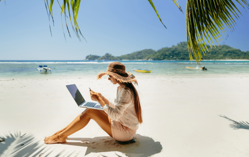 woman on seaside working on a computer