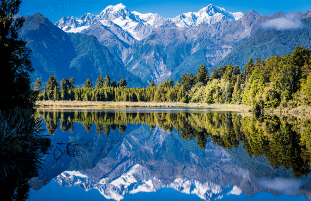 Stunning reflection of the Southern Alps on Lake Matheson in New Zealand – a nature-rich, tourist friendly country for adventurers
