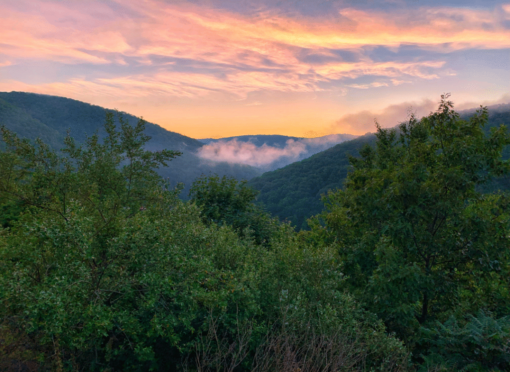 Sunset view over the Pocono Mountains with misty valleys, highlighting the region’s natural beauty and peaceful atmosphere.