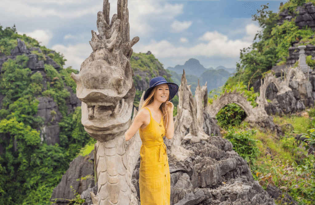 Female traveler in yellow dress exploring the famous dragon staircase at Hang Múa Peak in Ninh Binh, Vietnam – one of the top tourist friendly countries